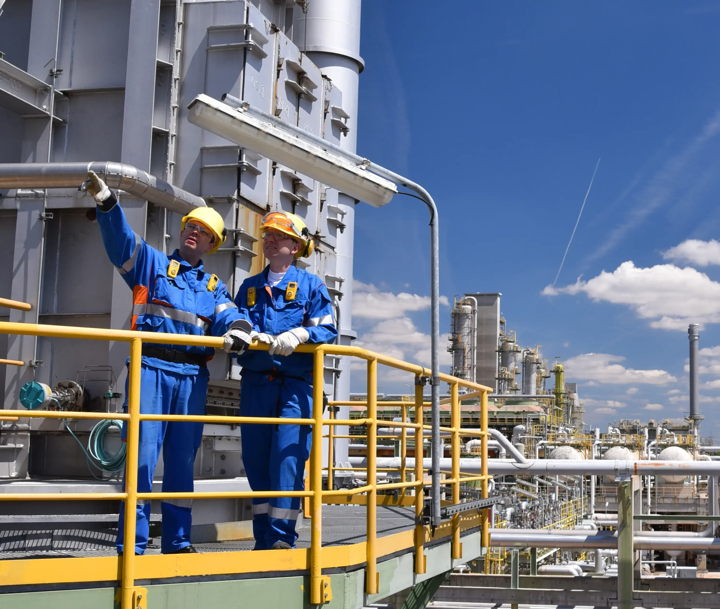 An image of two refinery engineers discussing the operation of a safety valve used to protect against excess pressure buildup