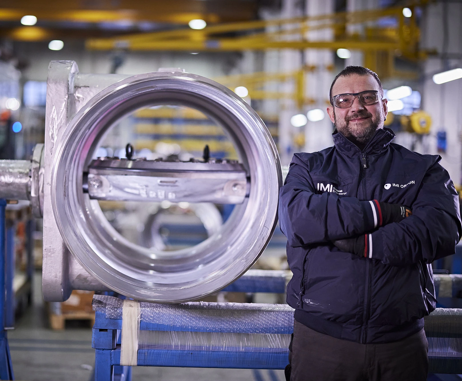 Expertly poised beside a valve, a man oversees IMI Orton's Italian facility, a hub of industrial innovation.