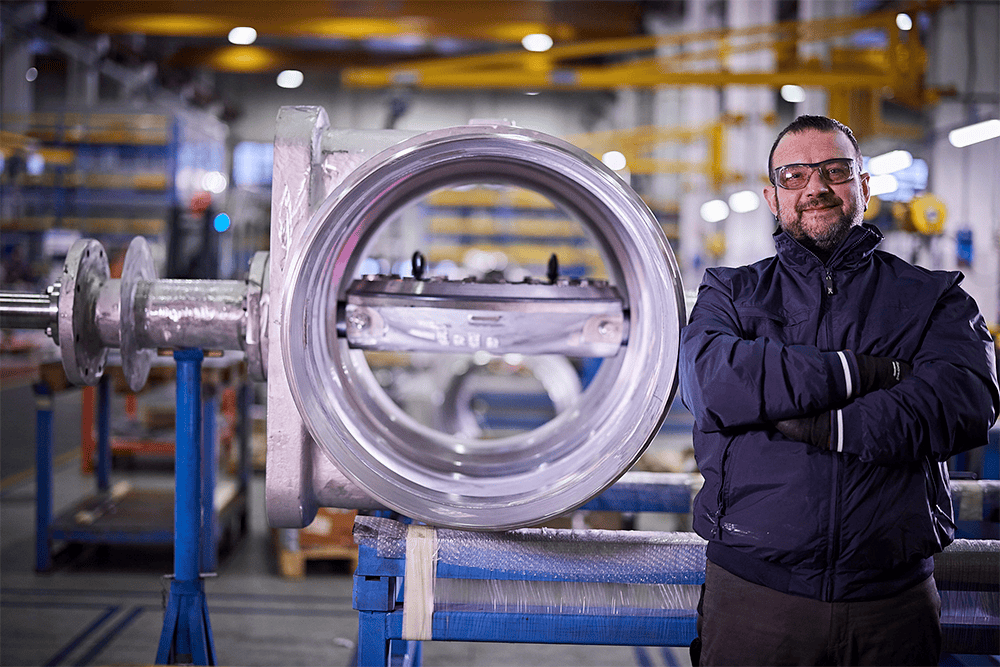 Expertly poised beside a valve, a man oversees IMI Orton's Italian facility, a hub of industrial innovation.